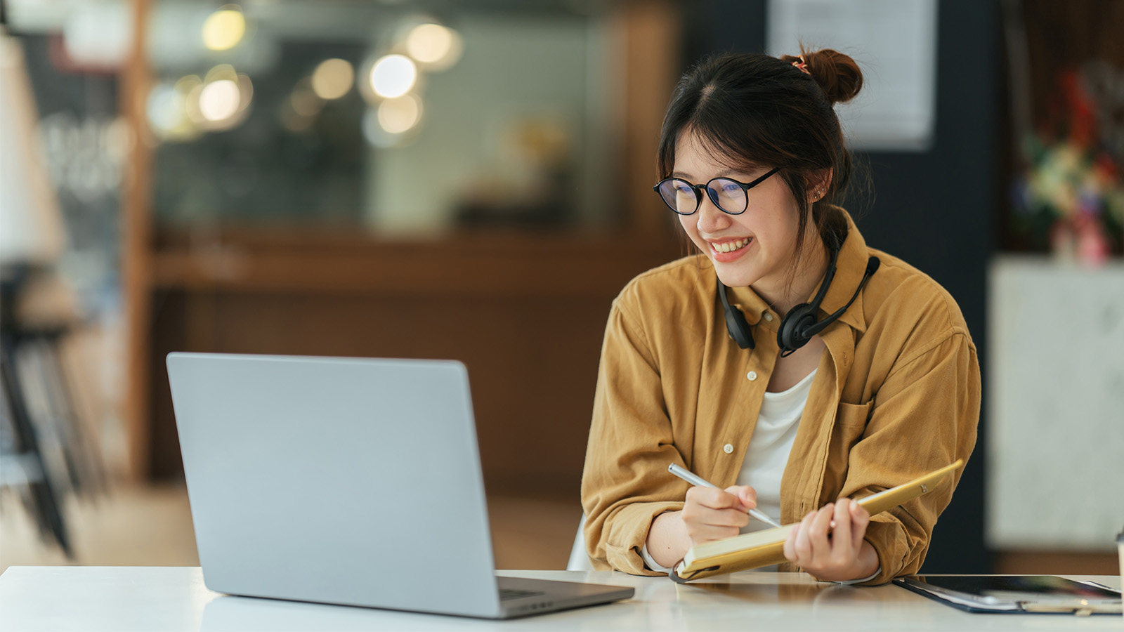 A female student working on her computer in a coffee shop.